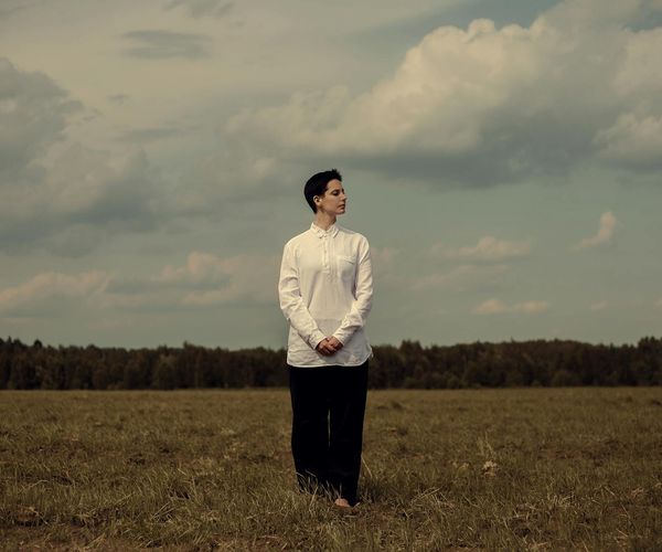 Person closing their eyes and breathing deeply in a bright, peaceful room.
